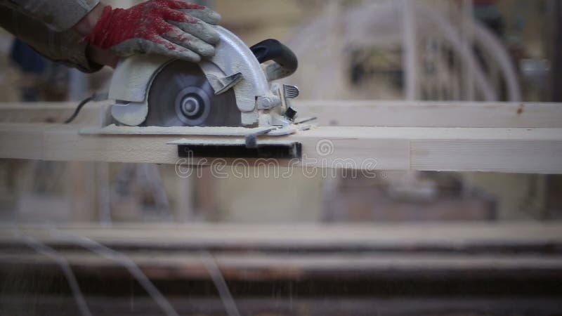 A carpenter saws off a board with a disk saw