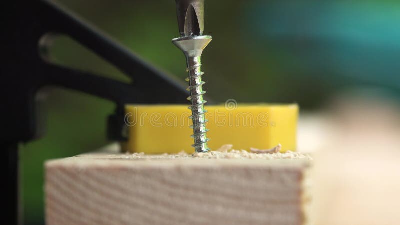 Carpenter saws a wooden bar with an electric saw