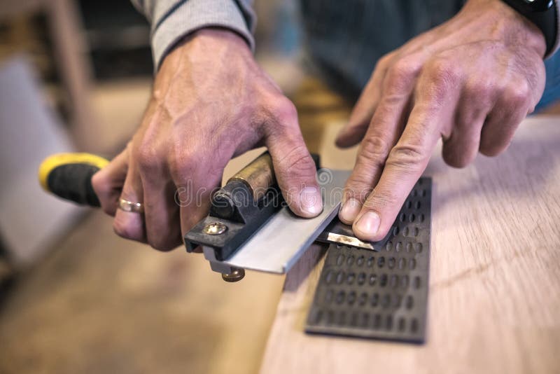 Carpenter sharpening a chisel close up view stock image