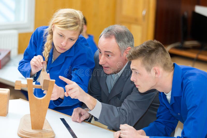 Carpenter with students in woodworking class stock photos