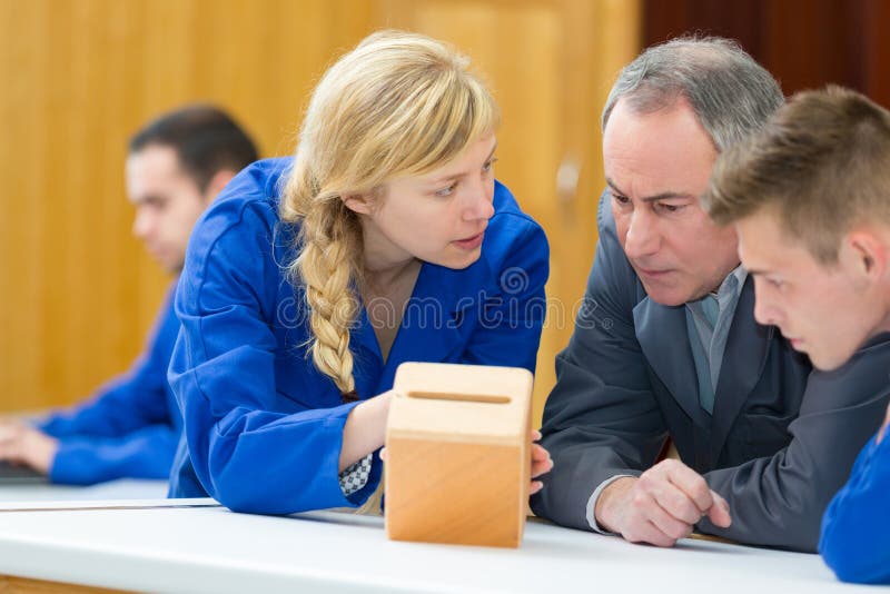 Carpenter with students in workshop assembling wood stock photos