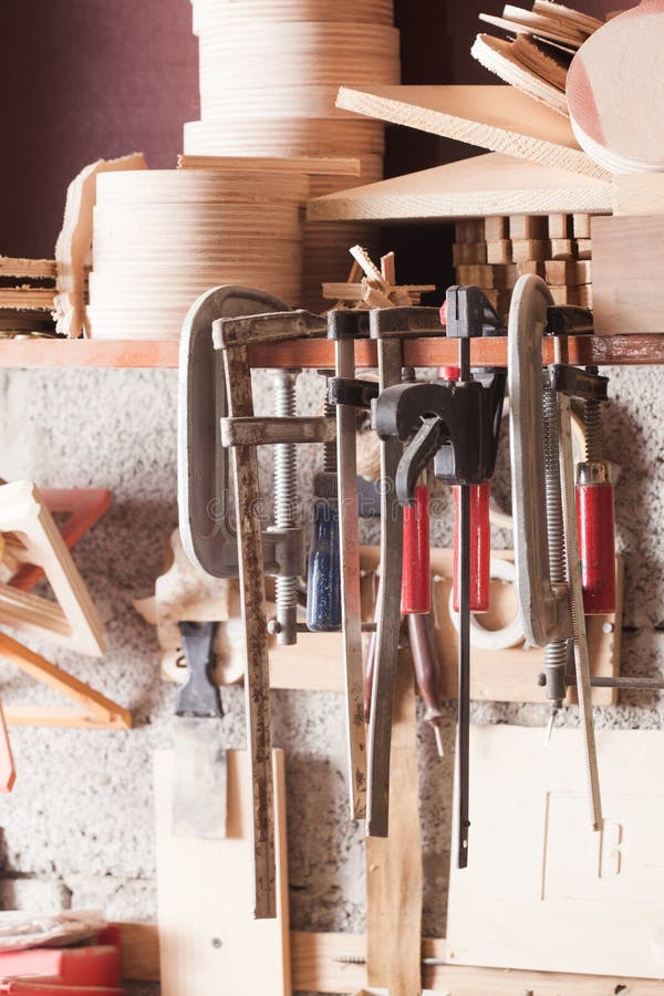 Carpenter tools fixed on the wall at workshop. Close view of set of various tools and instruments fixed on the wall at carpentry workshop.