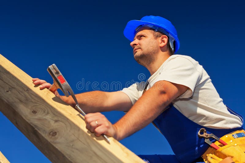 Carpenter on top of roof structure inspecting the building