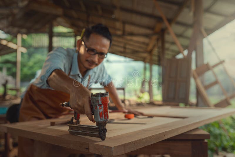 carpenter uses nail gun to assemble wood furniture factory carpenter uses nail gun to assemble wood furniture 226351604