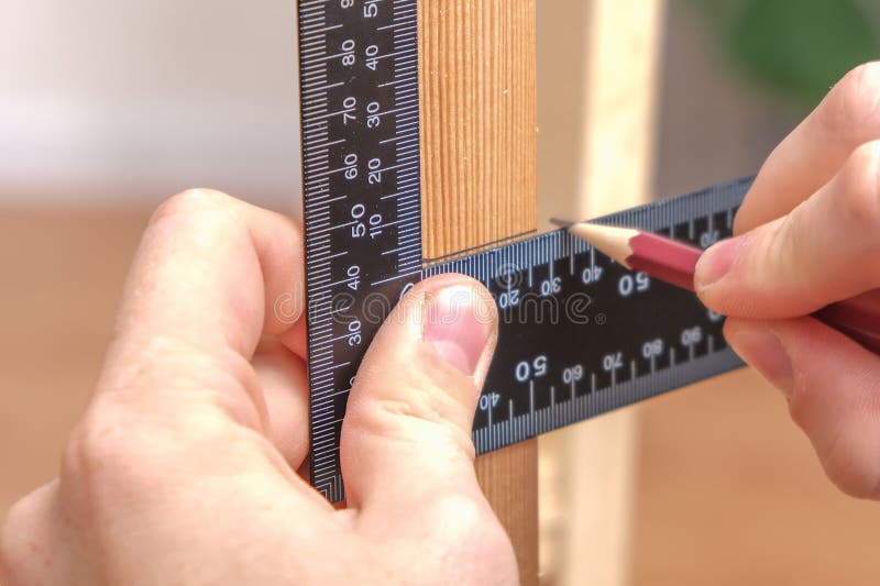 A Carpenter Using Carpenter Square To Mark the Line of Wood Cut for