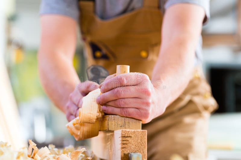 Carpenter with wood planer and workpiece in carpentry