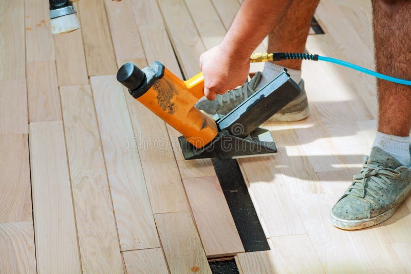 Carpenter Worker Installing Wood Parquet Board During Flooring W