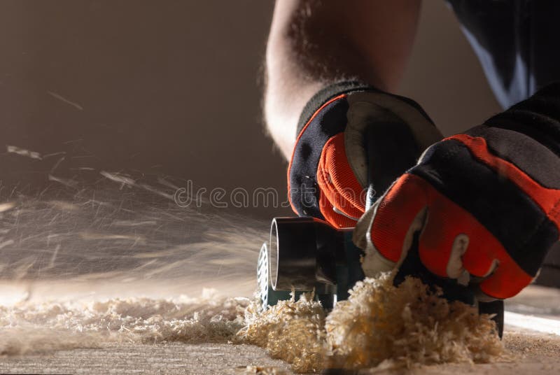 Carpenter working with electric planer stock images