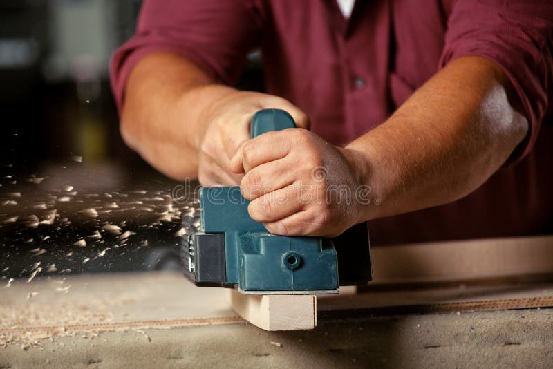 Carpenter working with electric planer. royalty free stock images