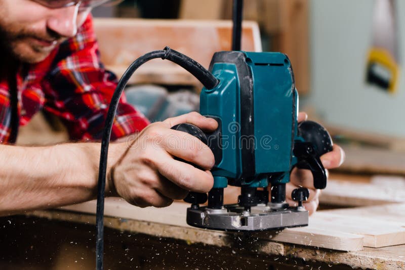 Carpenter working of manual hand milling machine in the carpentry workshop. joiner. stock images Carpenter working of manual hand milling machine in the carpentry workshop. joiner. stock images