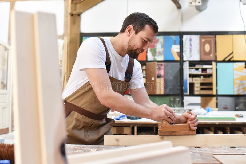 carpenter works in a joinery - workshop for woodworking and sawing stock photography carpenter works in a joinery - workshop for woodworking and sawing stock photography
