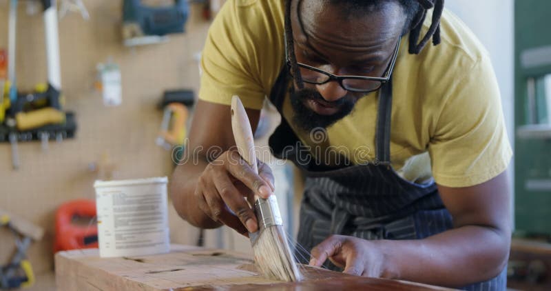 Carpentiere attento che dipinge plancia di legno 4k