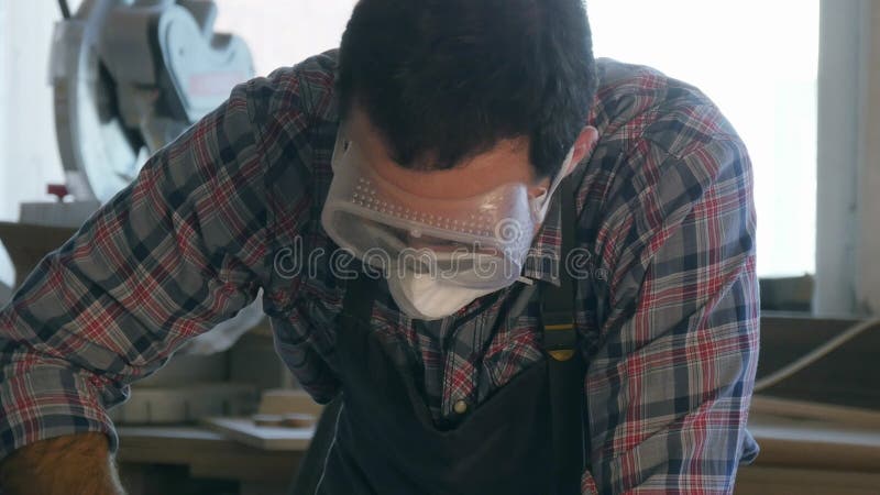 Carpentiere che lavora con lo strumento industriale in occhiali di protezione d'uso della fabbrica di legno fotografia stock libera da diritti Carpentiere che lavora con lo strumento industriale in occhiali di protezione d'uso della fabbrica di legno fotografia stock libera da diritti
