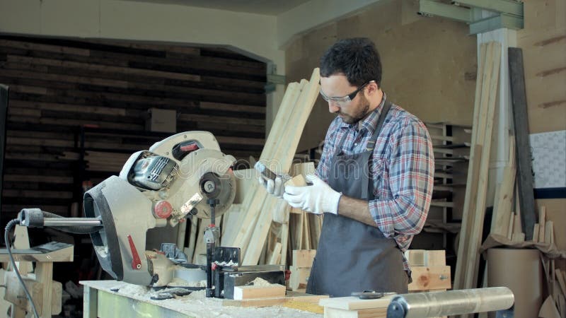 Carpentiere che lavora plancia di legno in officina fotografia stock libera da diritti Carpentiere che lavora plancia di legno in officina fotografia stock libera da diritti