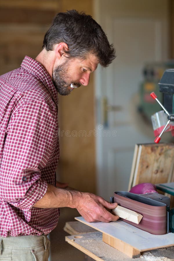 Carpentiere che per mezzo dello strumento della sabbiatrice elettrica immagini stock Carpentiere che per mezzo dello strumento della sabbiatrice elettrica immagini stock