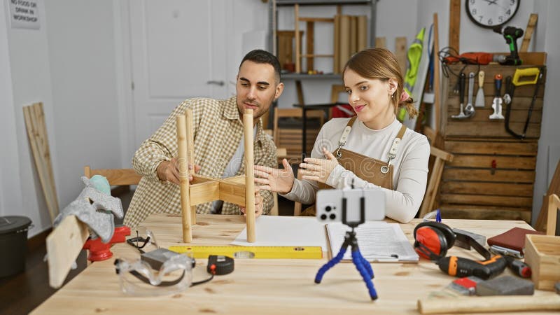 Carpentieri di uomini e donne collaborano in un'officina di lavorazione del legno attrezzata con saldature di mobilio fotografia stock