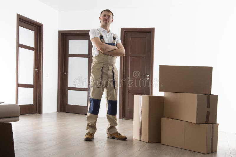 Carregador com as caixas de cartão no apartamento Motor na casa O internamento presta serviços de manutenção ao homem imagens de stock Carregador com as caixas de cartão no apartamento Motor na casa O internamento presta serviços de manutenção ao homem imagens de stock