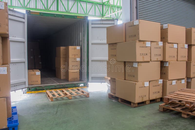 Carregamento de caixas de cartão de embarque e mercadorias em palete de madeira na doca de carregamento do contentor imagem de stock royalty free Carregamento de caixas de cartão de embarque e mercadorias em palete de madeira na doca de carregamento do contentor imagem de stock royalty free