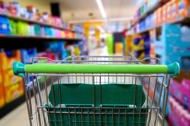 Empty shopping cart in the supermarket aisle. Rear view with perspective. Horizontal composition. Empty shopping cart in the supermarket aisle. Rear view with perspective. Horizontal composition