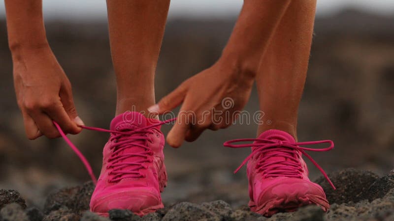 Carrera de mujeres atando cordones de zapatos corriendo - corredor de carreras de chicas Cierre de las piernas femeninas y zapato