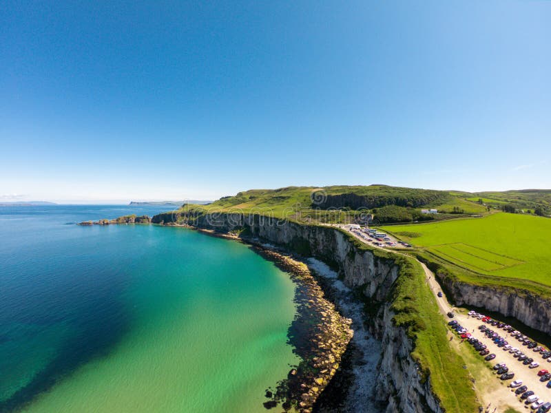 Carrick uma ponte de corda de Rede em Ballintoy Irlanda do Norte Vista aérea em penhascos e em água de Oceano Atlântico de turque foto de stock Carrick uma ponte de corda de Rede em Ballintoy Irlanda do Norte Vista aérea em penhascos e em água de Oceano Atlântico de turque foto de stock