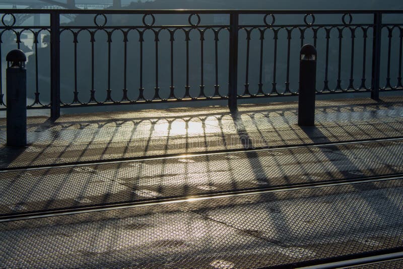 Carriles y cerca del hierro en luz de la mañana Configuraci?n urbana moderna Sombra de la cerca del metal temprano por la mañana fotografía de archivo Carriles y cerca del hierro en luz de la mañana Configuraci?n urbana moderna Sombra de la cerca del metal temprano por la mañana fotografía de archivo