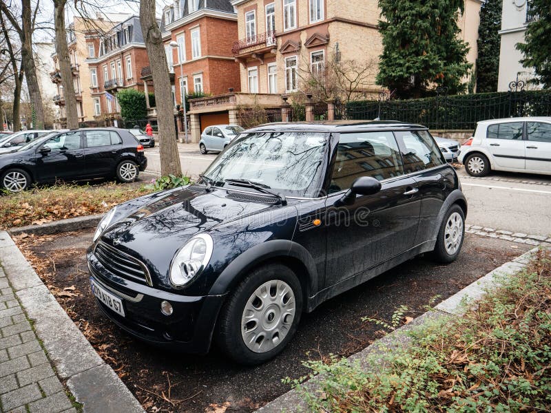 Carro Black Mini Cooper estacionado na rua da cidade com casas de luxo ao fundo fotografia de stock royalty free Carro Black Mini Cooper estacionado na rua da cidade com casas de luxo ao fundo fotografia de stock royalty free