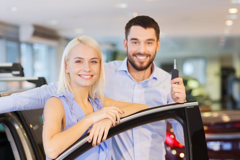 Auto business, car sale, consumerism and people concept - happy couple buying car in auto show or salon. Auto business, car sale, consumerism and people concept - happy couple buying car in auto show or salon