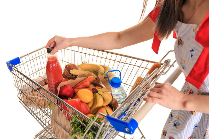 Carro de la compra lleno en la tienda con las verduras frescas y el primer de las manos fotos de archivo libres de regalías Carro de la compra lleno en la tienda con las verduras frescas y el primer de las manos fotos de archivo libres de regalías