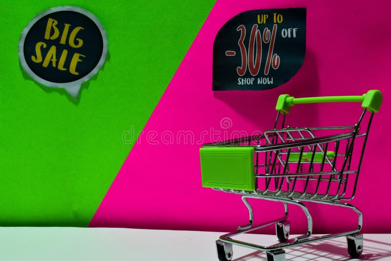 Carro de la compra verde la venta grande atada y hasta -30% apagado, ahora hacen compras texto en fondo verde y rosado foto de archivo Carro de la compra verde la venta grande atada y hasta -30% apagado, ahora hacen compras texto en fondo verde y rosado foto de archivo