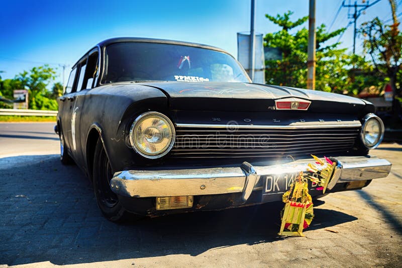 Carro retro de Holden com o amortecedor do espelho do cromo na rua do fundo no ubud no céu azul do fundo foto de stock Carro retro de Holden com o amortecedor do espelho do cromo na rua do fundo no ubud no céu azul do fundo foto de stock