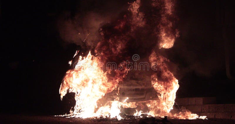 Carro travado no fogo com chamas dos larges