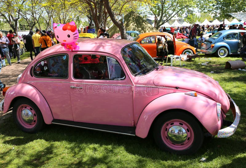 Carro velho cor-de-rosa de Volkswagen Beetle no carnaval alaranjado da flor foto de stock Carro velho cor-de-rosa de Volkswagen Beetle no carnaval alaranjado da flor foto de stock