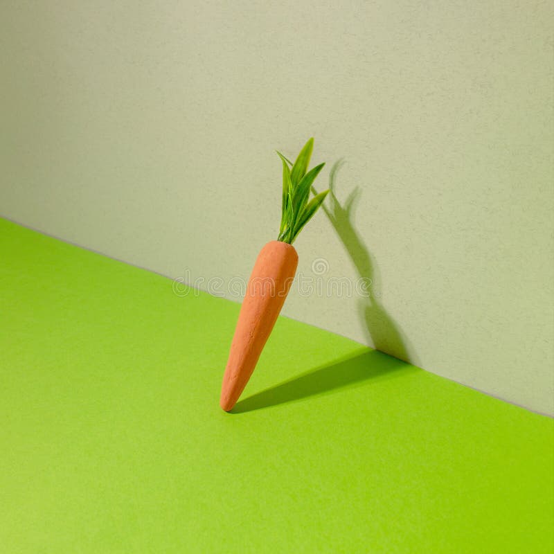 Carrot on green and gray background. Minimal Easter concept. Spring minimal composition stock image