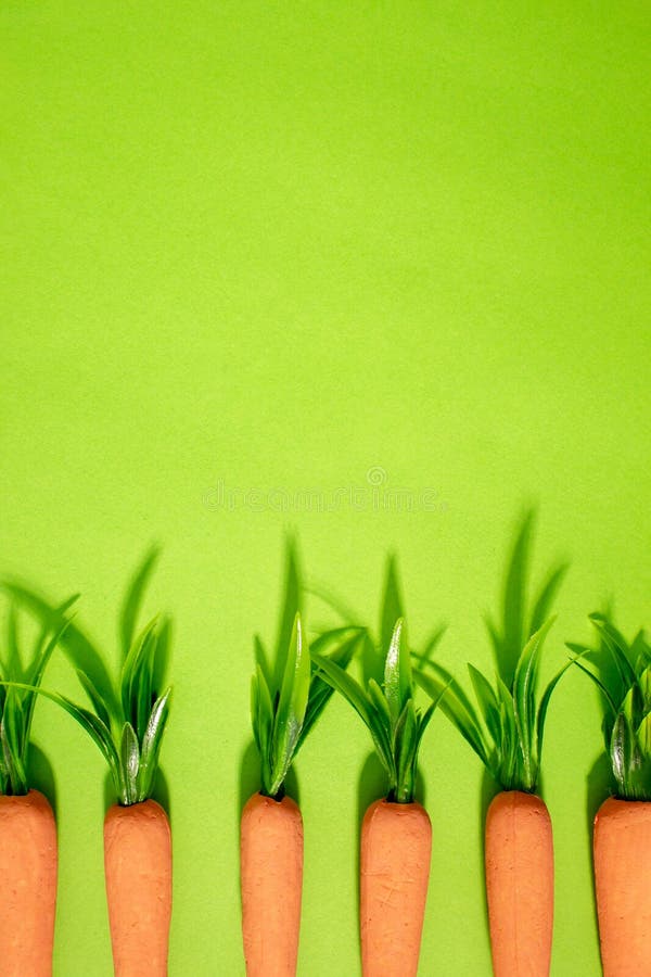 Carrots on pastel yellow. Minimal Easter concept. Spring minimal composition stock images