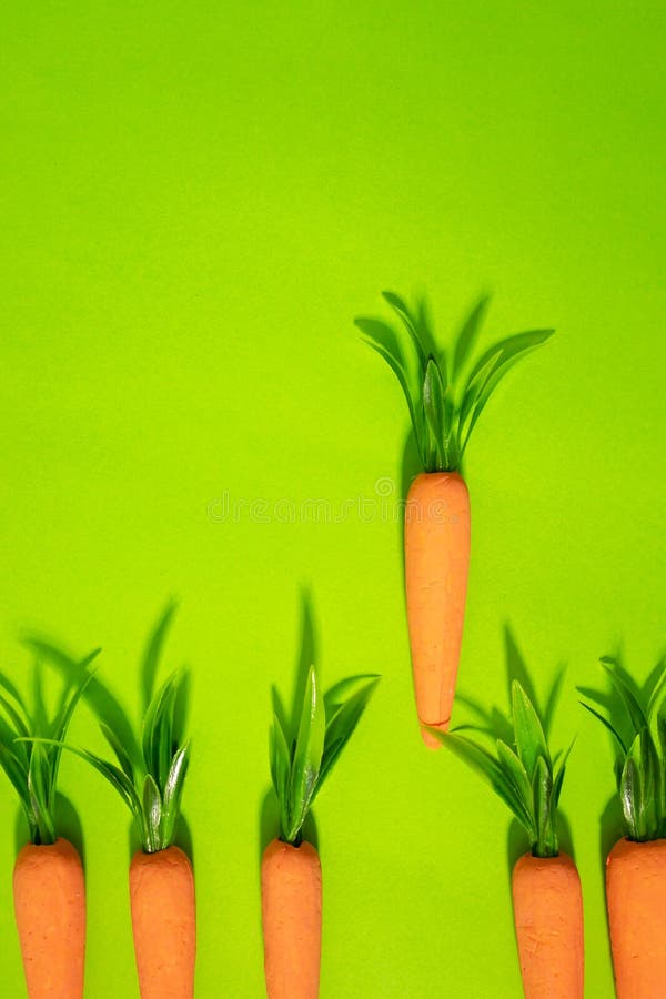 Carrots on pastel yellow. Minimal Easter concept. Spring minimal composition royalty free stock photo