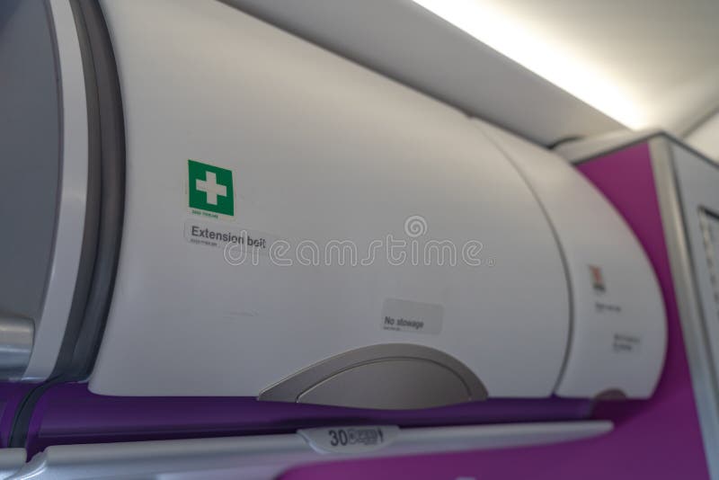 Carry-on luggage in overhead storage compartment on commercial airplane stock photos Carry-on luggage in overhead storage compartment on commercial airplane stock photos