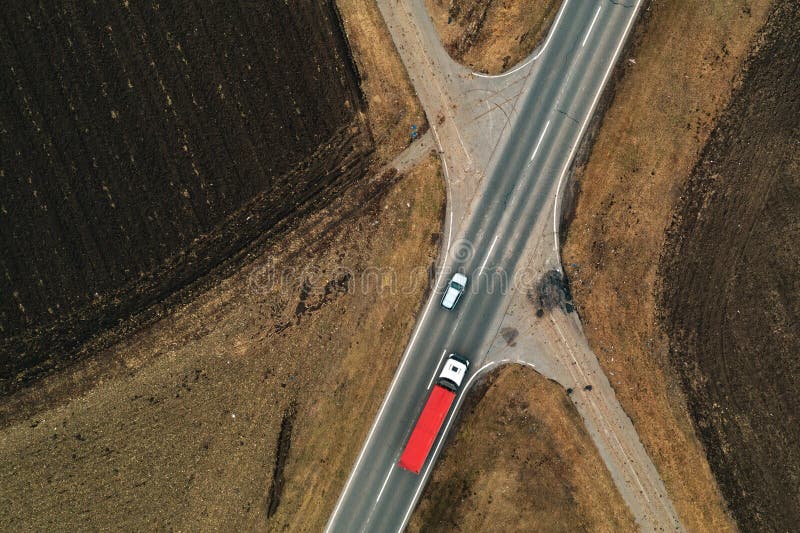 Cars and trucks on the road through countryside, aerial view