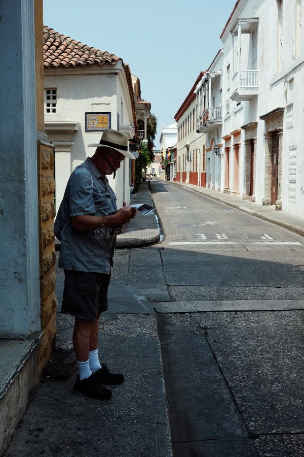 Cartagena/Colombia - 19 BRENGEN 2016 in de war: mens die een kaart controleren op de straat in het historische deel van de stad royalty-vrije stock foto's Cartagena/Colombia - 19 BRENGEN 2016 in de war: mens die een kaart controleren op de straat in het historische deel van de stad royalty-vrije stock foto's