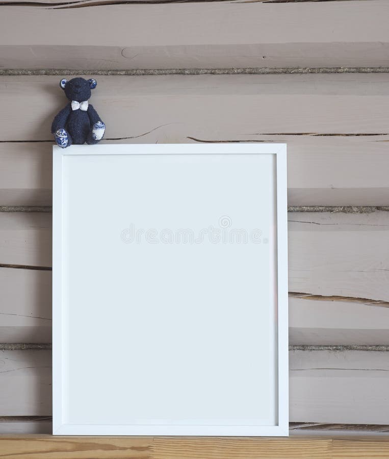 Cartaz interior vazio do Livro Branco, com o brinquedo azul do urso, zombaria vertical isolada acima com quadro no fundo de madei fotografia de stock Cartaz interior vazio do Livro Branco, com o brinquedo azul do urso, zombaria vertical isolada acima com quadro no fundo de madei fotografia de stock