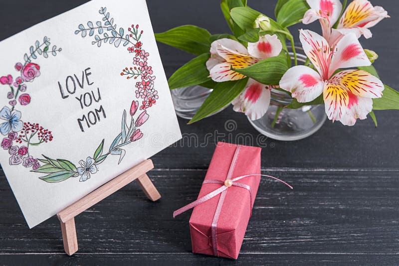 Carte avec amour d'expression vous maman, fleurs et boîte-cadeau sur la table Salutation pour le jour de m?re photo libre de droits Carte avec amour d'expression vous maman, fleurs et boîte-cadeau sur la table Salutation pour le jour de m?re photo libre de droits