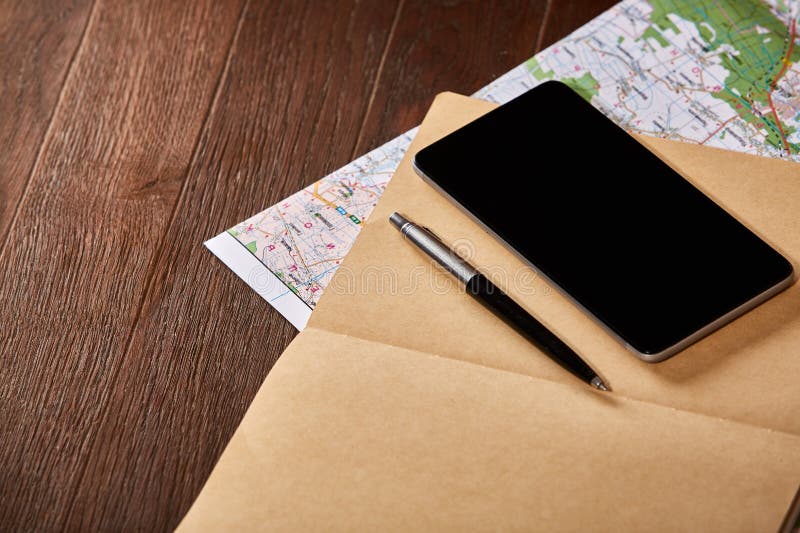 Carte, carnet, stylo et téléphone noir sur le fond en bois brun image libre de droits Carte, carnet, stylo et téléphone noir sur le fond en bois brun image libre de droits