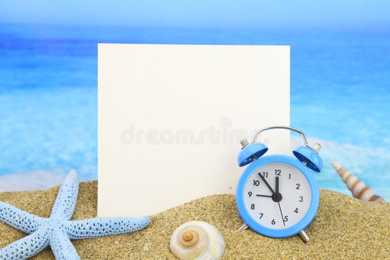 Summer time. Paper card and alarm clock on the beach. Summer time. Paper card and alarm clock on the beach