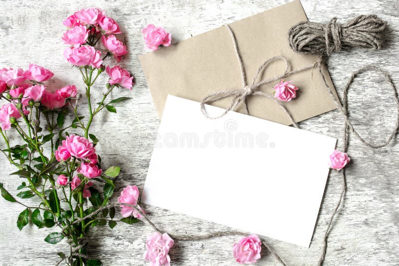 Carte de voeux blanche vierge avec le bouquet et l'enveloppe roses de roses photographie stock Carte de voeux blanche vierge avec le bouquet et l'enveloppe roses de roses photographie stock