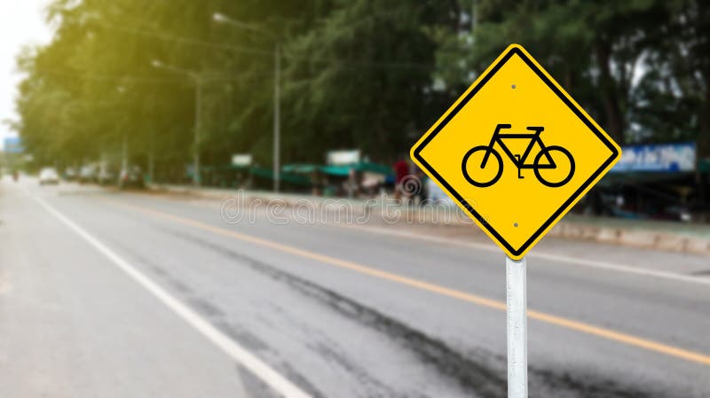 Yellow sign with graphic of bicycle to warn traffics to beware of bicycle lane in local park. Yellow sign with graphic of bicycle to warn traffics to beware of bicycle lane in local park