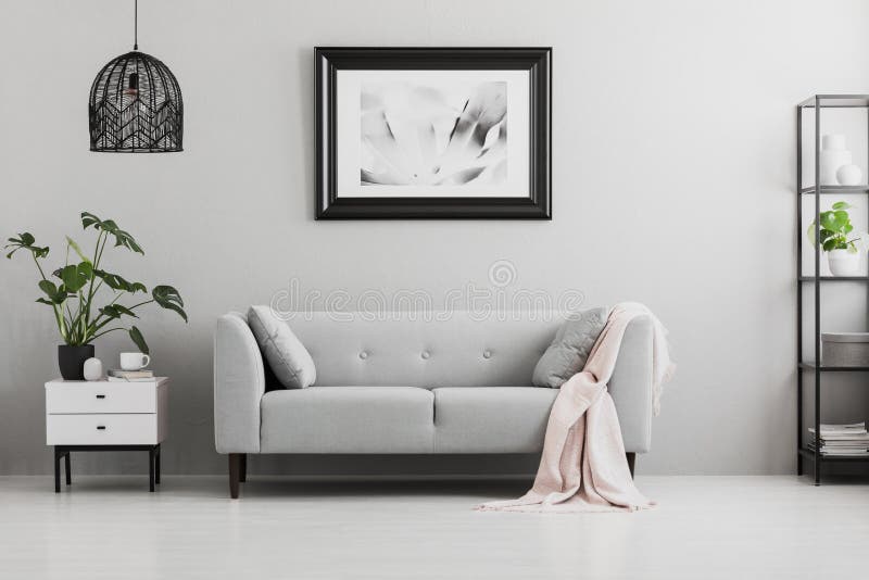 Cartel sobre el sofá gris con la manta rosada en interior de la sala de estar fotografía de archivo libre de regalías Cartel sobre el sofá gris con la manta rosada en interior de la sala de estar fotografía de archivo libre de regalías