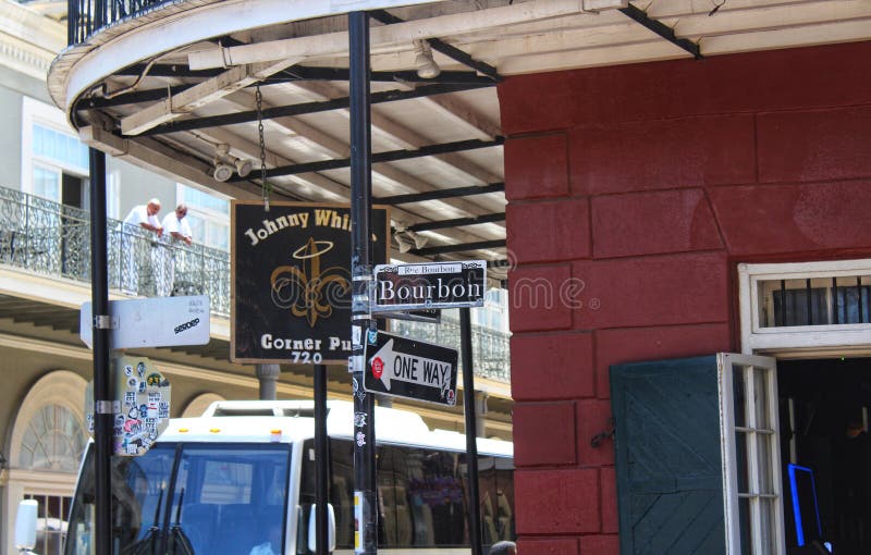 New Orleans/LA-US 7/24/18 Bourbon street sign along with a one way sign on the corner of a busy New Orleans street at a bar location with a tourist bus in the background. New Orleans/LA-US 7/24/18 Bourbon street sign along with a one way sign on the corner of a busy New Orleans street at a bar location with a tourist bus in the background