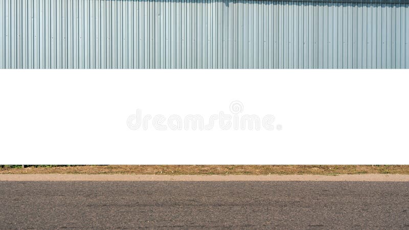 Large blank billboard on road with corrugated metal wall in background ready for graphic display or advertising. Perfect for high visibility in urban setting. Large blank billboard on road with corrugated metal wall in background ready for graphic display or advertising. Perfect for high visibility in urban setting.