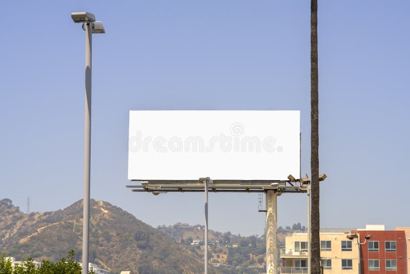 Blank white billboard in Los Angeles, California with old apartment buildings framing the edges and the Hollywood Hills in the background. Blank white billboard in Los Angeles, California with old apartment buildings framing the edges and the Hollywood Hills in the background