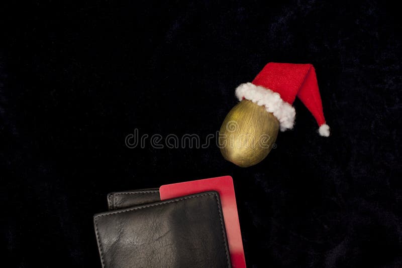 Cartera con una tarjeta de banco, huevo de oro Santa Claus foto de archivo libre de regalías Cartera con una tarjeta de banco, huevo de oro Santa Claus foto de archivo libre de regalías